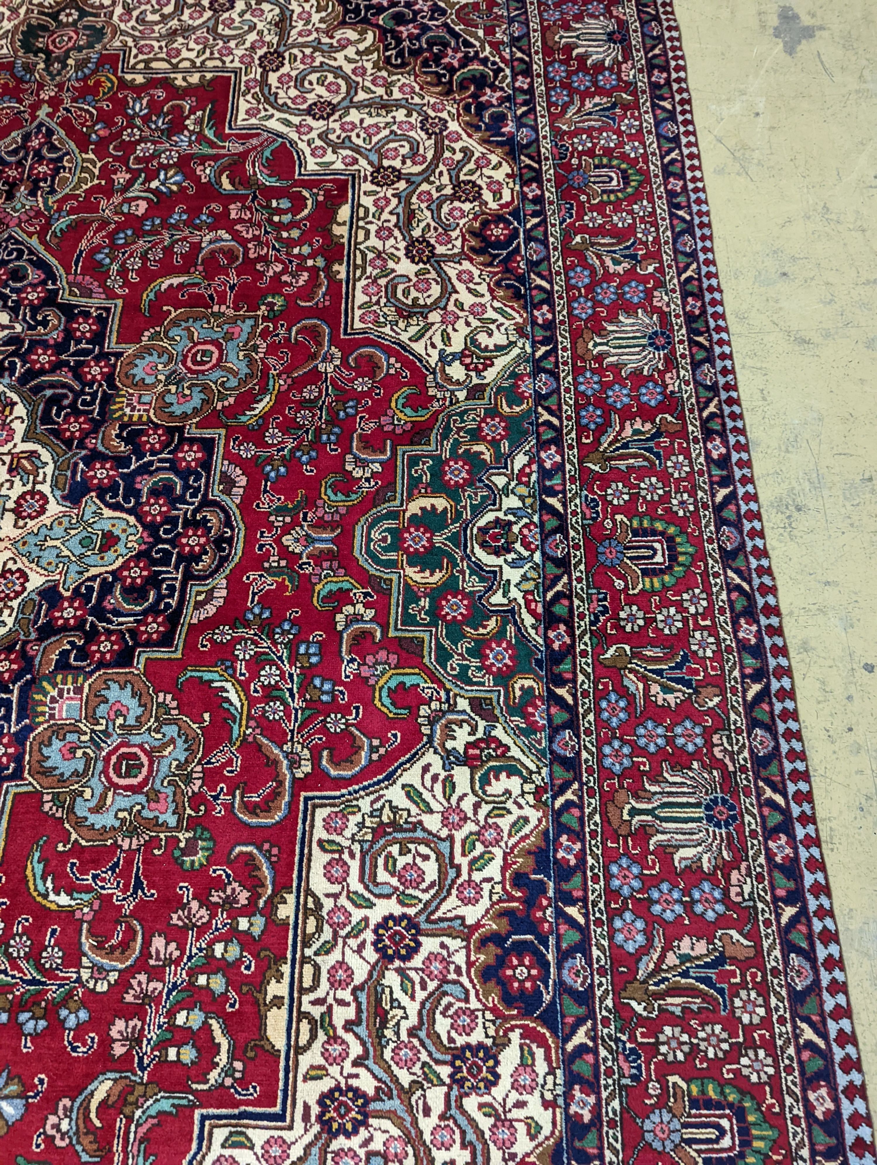 A Tabriz red ground carpet, 405 x 292cm